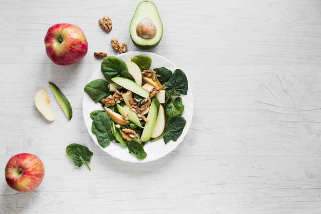 Foto manzanas y aguacate cerca de ensalada