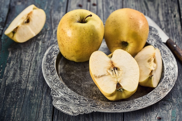 Manzanas amarillas en una bandeja de metal en estilo rústico