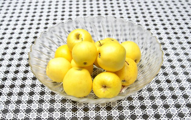 Foto manzanas amarillas en un cuenco de vidrio grande en una imagen de mesa de un