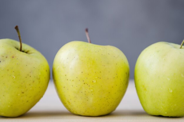 Manzanas amarillas frescas en una mesa de madera