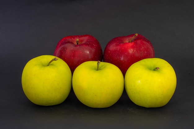 Manzanas amarillas y rojas sobre un fondo negro