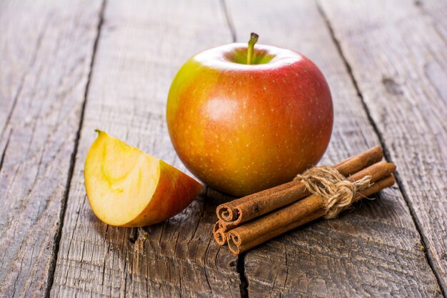 Foto manzanas con canela en mesa de madera