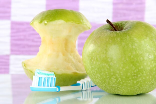 Manzanas con un cepillo de dientes en el estante del baño.