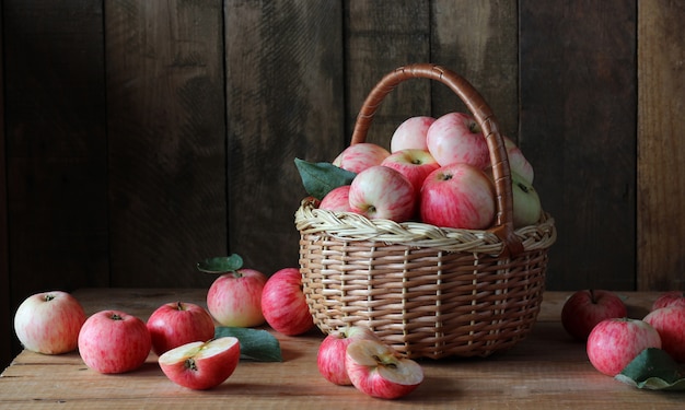 Manzanas en cesta en una tabla de madera.