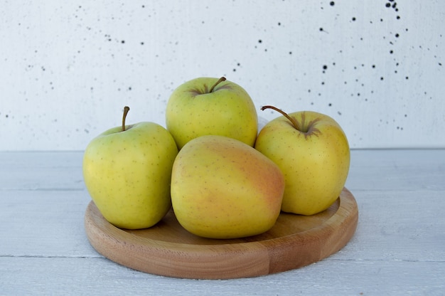 manzanas doradas sobre un soporte de madera un fondo de madera clara