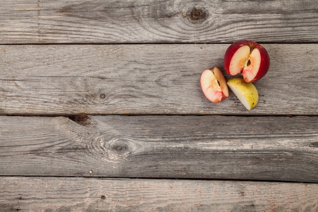 Manzanas enteras y en rodajas en la mesa de madera