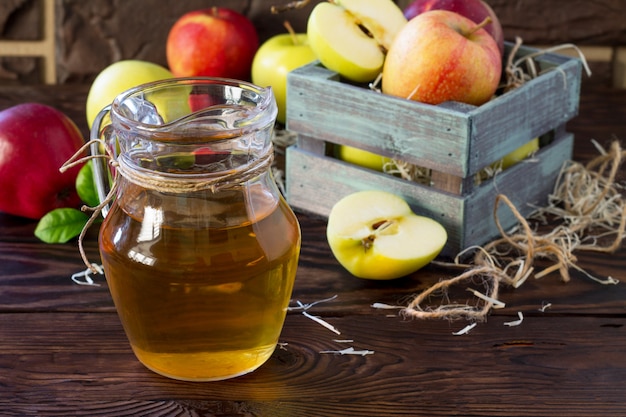 Manzanas frescas en una caja de madera y jugo