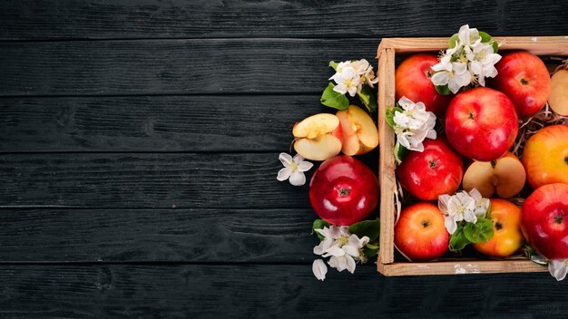 Manzanas frescas en una cesta de madera Sobre un fondo de madera Vista superior Espacio de copia