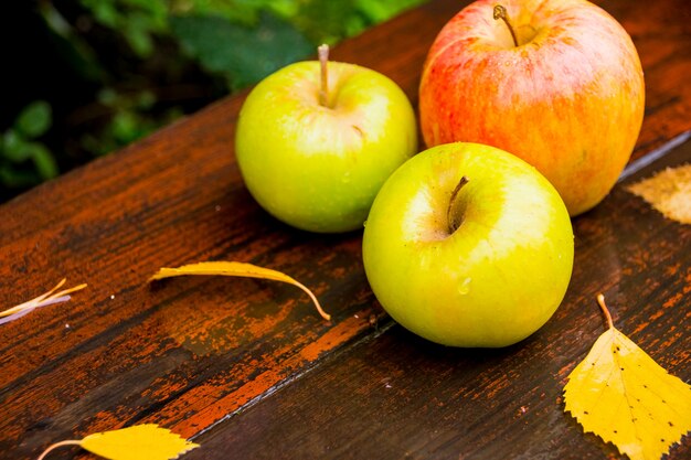 Manzanas frescas en una mesa de madera mojada