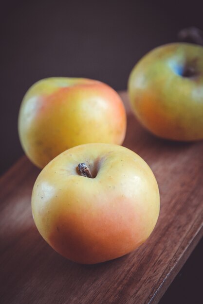 Manzanas frescas orgánicas sobre tabla de cortar de madera