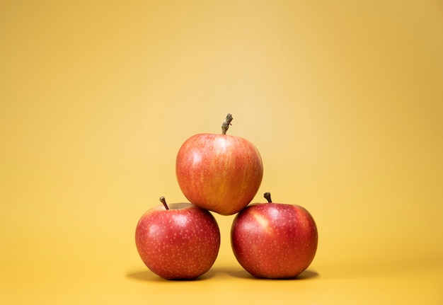 Foto manzanas frescas sobre un fondo amarillo brillante en un estilo publicitario de foodphoto. horizontal