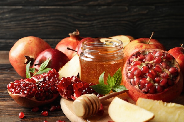 Manzanas, granadas y miel en madera, de cerca