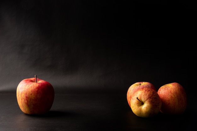 Manzanas, hermosas manzanas dispuestas sobre fondo negro, retrato de bajo perfil, enfoque selectivo.