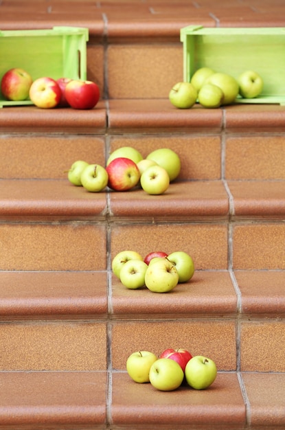 Foto manzanas jugosas esparcidas por las escaleras