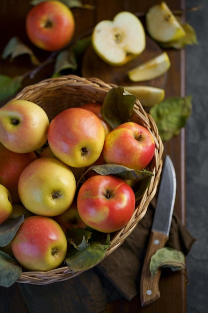 Manzanas maduras en una canasta con hojas alrededor