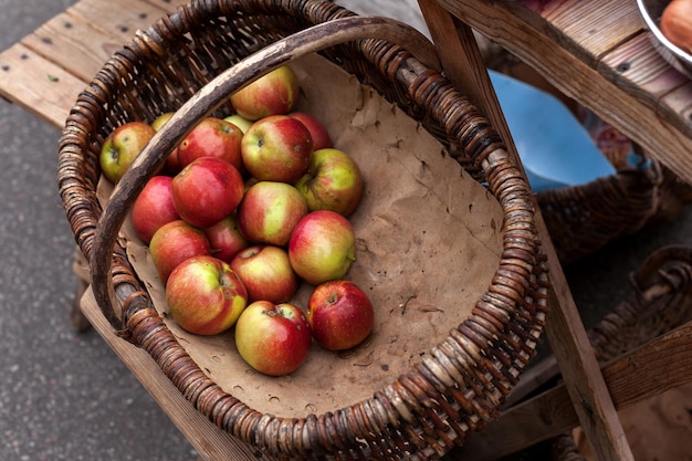 Foto manzanas maduras en una cesta de mimbre comercio de productos de temporada en el mercado callejero