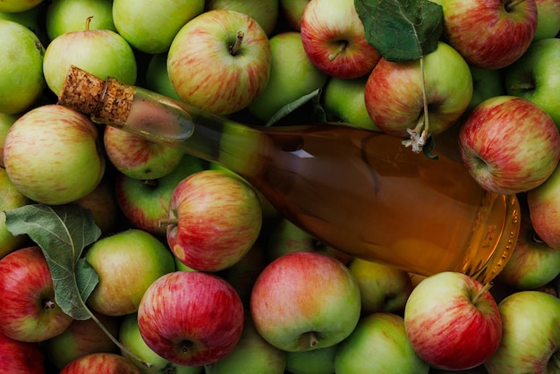 Manzanas maduras frescas y vinagre de sidra de manzana sobre la mesa Fondo claro