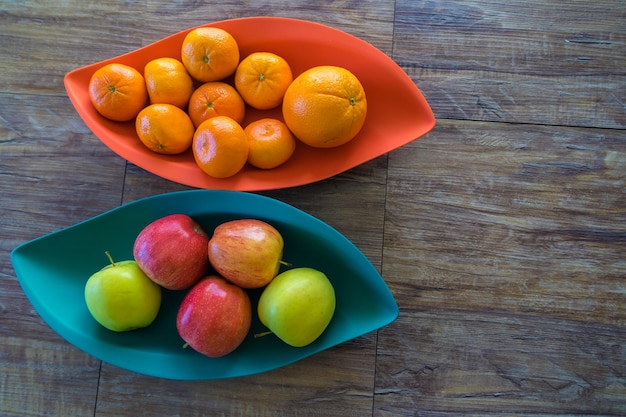 Manzanas naranjas y mandarinas ecológicas en bandejas