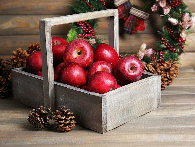 Manzanas de Navidad en mesa de madera