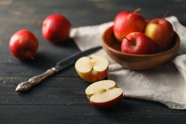 Manzanas orgánicas saludables en un tazón sobre tabla de madera. Comida sana