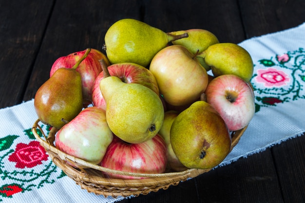 Manzanas y peras en una cesta en una servilleta