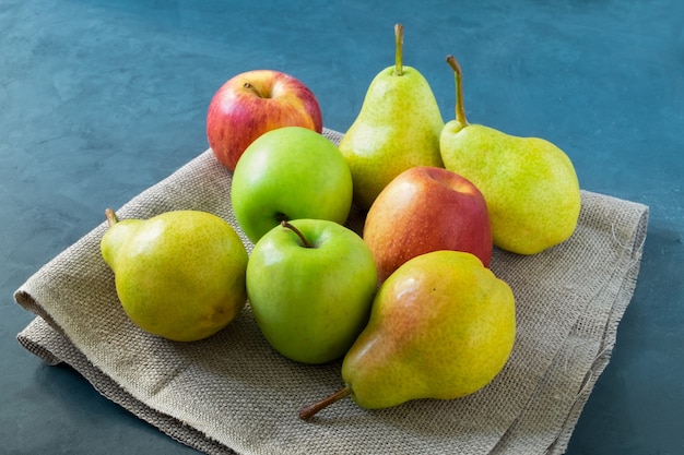 Manzanas y peras maduras en la mesa