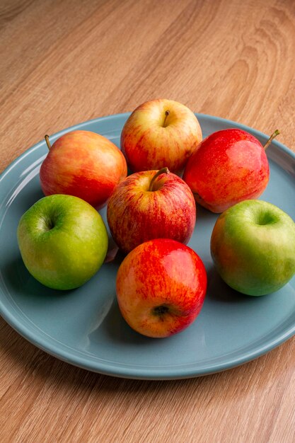 manzanas en un plato azul claro en una mesa de madera