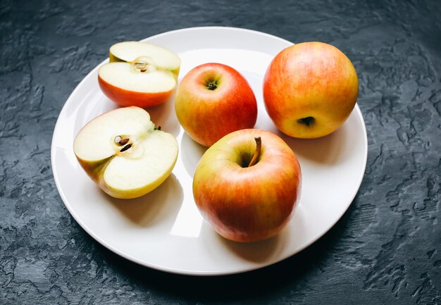 Manzanas en el plato blanco Foto de naturaleza muerta Fondo negro