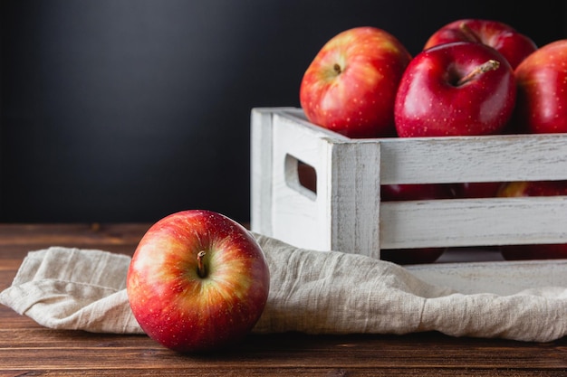Manzanas rojas en una caja sobre un fondo de madera