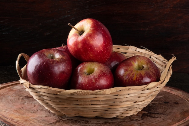 Foto manzanas rojas en canasta con fondo de madera