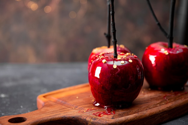 Manzanas rojas en caramelo close up soft focus un regalo original para una mesa festiva de halloween decorada