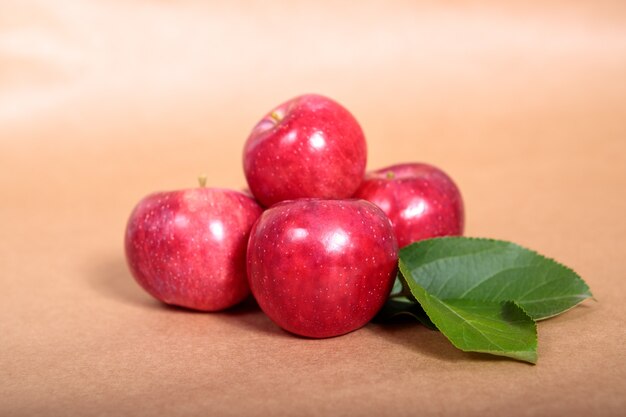 Foto las manzanas rojas con follaje verde se encuentran sobre un fondo claro. espacio para texto.