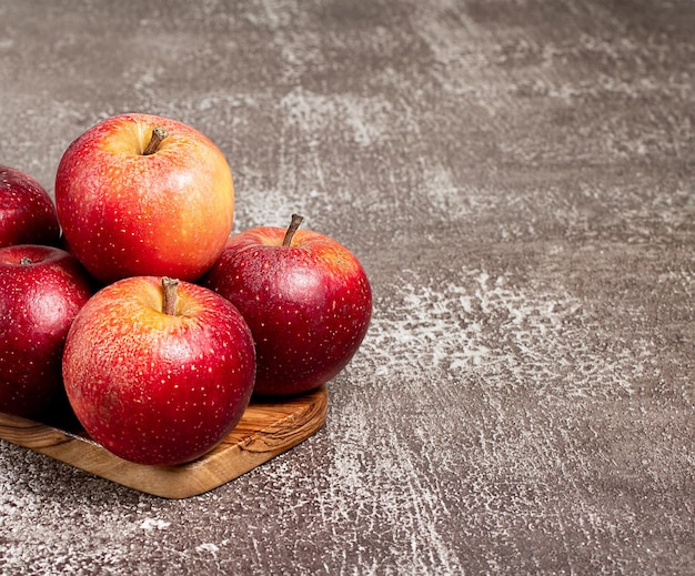 Manzanas rojas frescas en un espacio de mesa marrón para texto