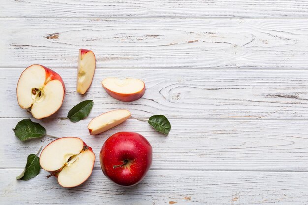 Foto manzanas rojas frescas con hojas verdes en la mesa de madera sobre fondo de madera vista superior espacio libre para texto