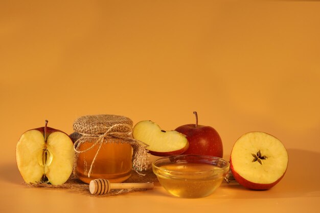 Manzanas rojas frescas con miel sobre fondo amarillo con espacio para copiar. banquete de manzana
