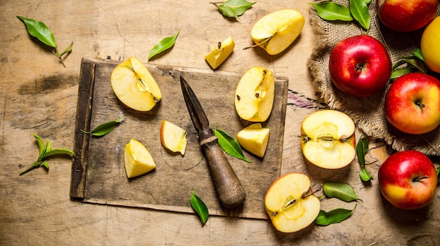 Manzanas rojas frescas, picadas en el tablero viejo