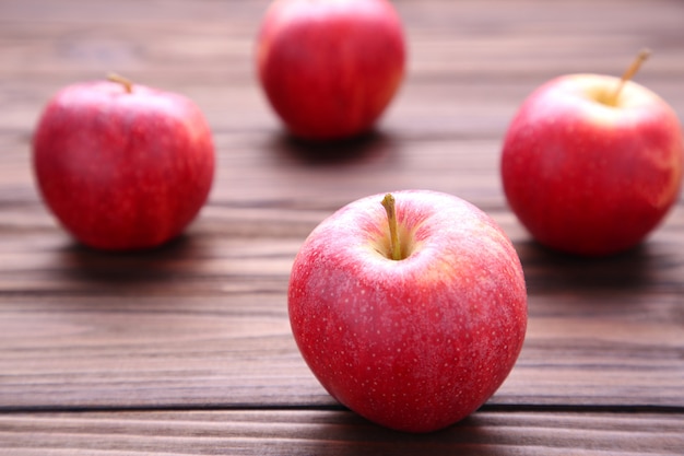 Manzanas rojas frescas sobre fondo de madera. Manzanas sabrosas en mesa marrón