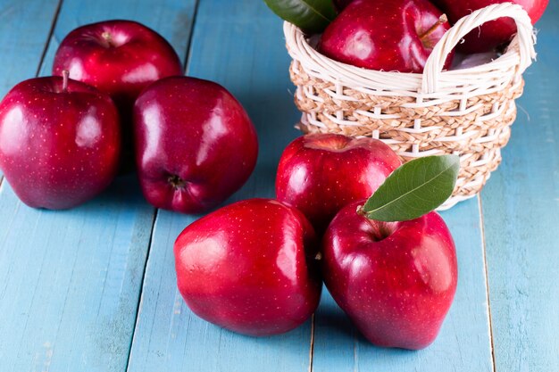 Manzanas rojas con hojas sobre la mesa