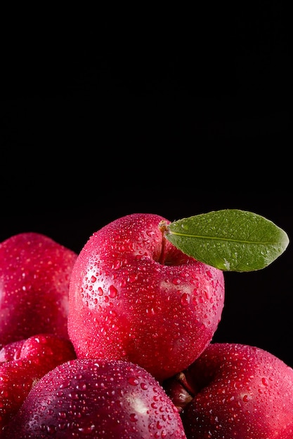 Manzanas rojas con hojas sobre la mesa