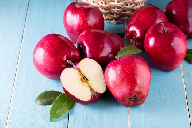 Manzanas rojas con hojas sobre la mesa