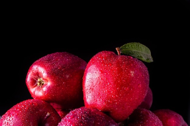 Manzanas rojas con hojas sobre la mesa