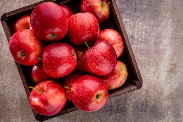 Manzanas rojas maduras en caja de madera. Vista superior con espacio para su texto.