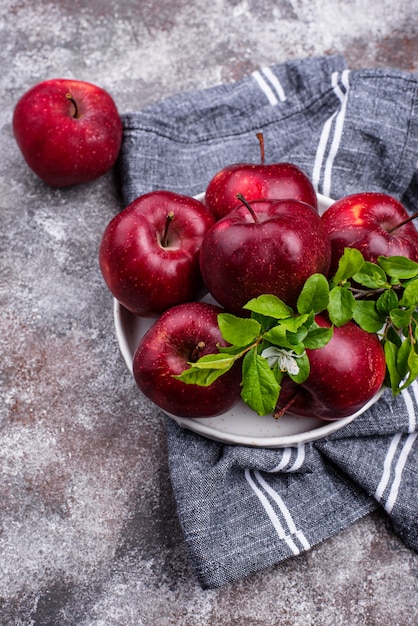 Manzanas rojas maduras frescas en mesa gris