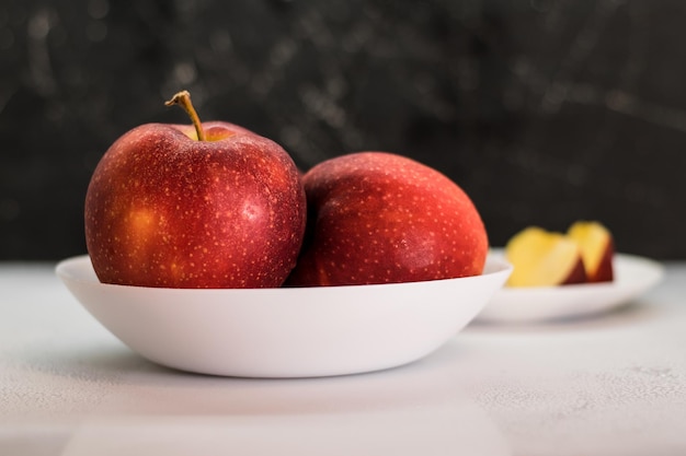 Manzanas rojas maduras con gotas de agua sobre un fondo oscuro