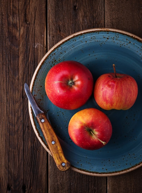 Manzanas rojas en placa azul