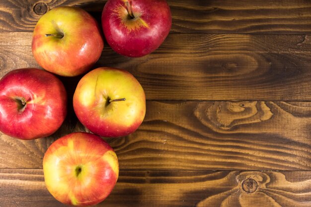 Manzanas rojas sobre mesa de madera. Vista superior, espacio de copia