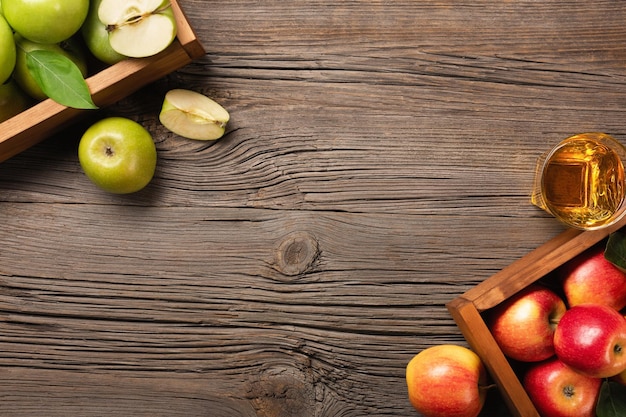 Manzanas rojas y verdes maduras en caja de madera sobre una mesa de madera. Vista superior con espacio para su texto.