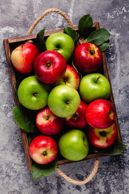 Manzanas rojas y verdes maduras en caja de madera. Vista superior con espacio de copia.