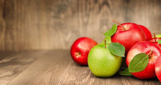 Foto manzanas rojas y verdes en una mesa de madera