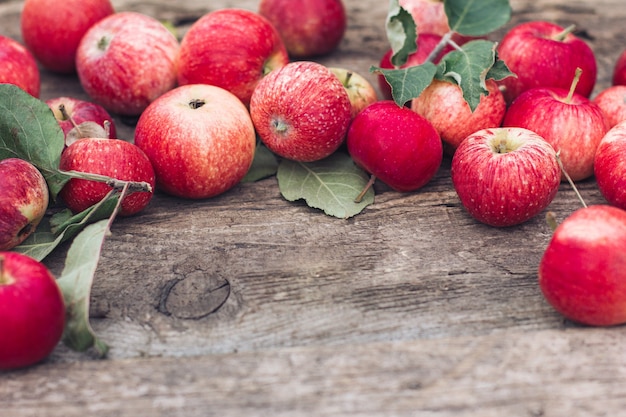 Las manzanas rojas yacen sobre una mesa de madera. Temporada de cosecha de otoño, humor otoñal.